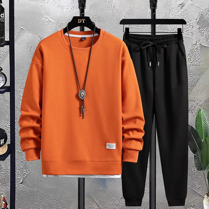 Jogging-Set vorne für Herren mit orangefarbenem Pullover und schwarzer Hose